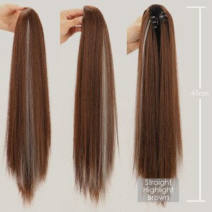 K&ouml;nnte beinhalten: Eine lange, gerade braune Haarverl&auml;ngerung mit hellblonden Str&auml;hnen. Die Verl&auml;ngerung ist 45 cm lang und hat einen Clip-In-Mechanismus.