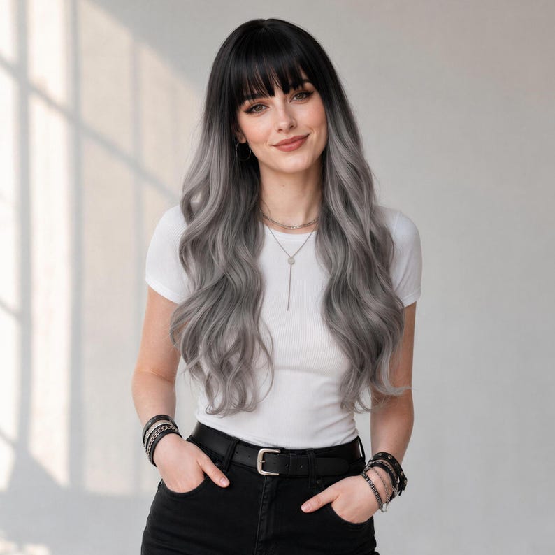 May include: A long, wavy wig featuring a dark black base at the roots that transitions into a light silver-gray color toward the ends, styled with straight-cut bangs. The hair is worn with a plain white short-sleeved t-shirt and black pants.