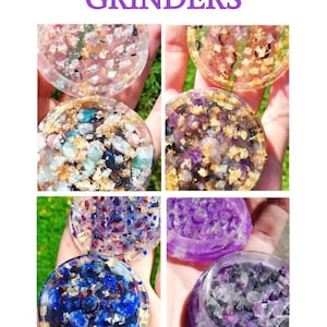 May include: Four different crystal orgonite grinders. Each grinder has a different colour scheme and features a variety of crystals embedded in the resin. The grinders are made of clear resin and have a gold-coloured metal ring around the edge. The grinders are all in focus and the image is well-lit.
