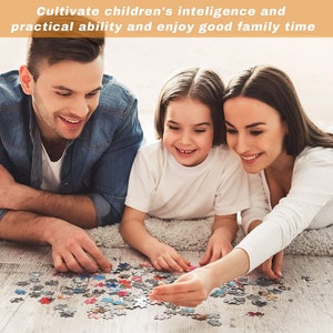 May include: A family of three, a man, a woman, and a young girl, are working together on a colorful jigsaw puzzle on the floor. They are all smiling and seem to be enjoying their time together.