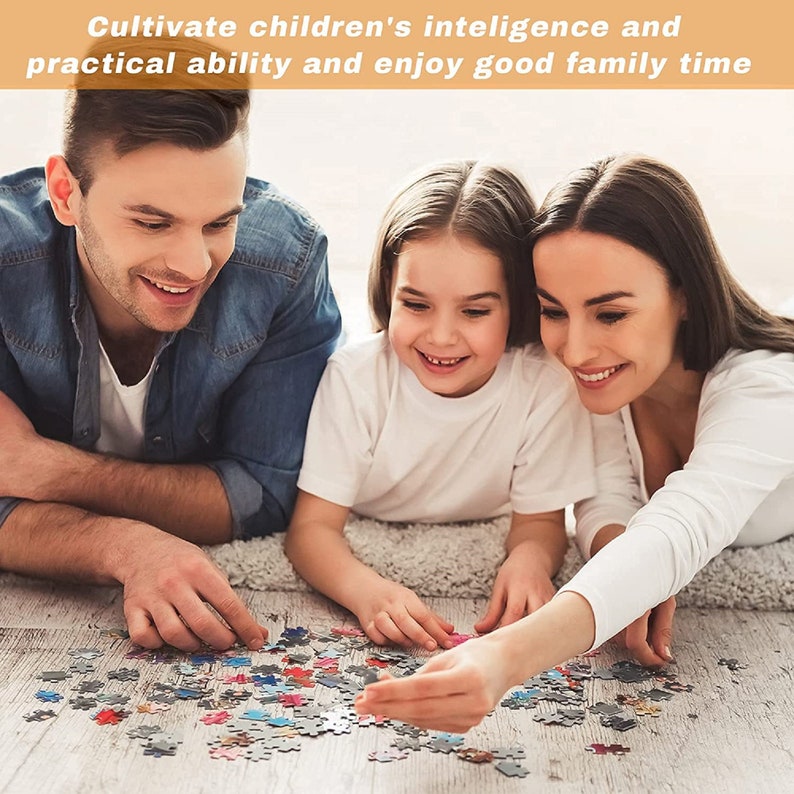 May include: A family of three, a man, a woman, and a young girl, are working together on a colorful jigsaw puzzle on the floor. They are all smiling and seem to be enjoying their time together.