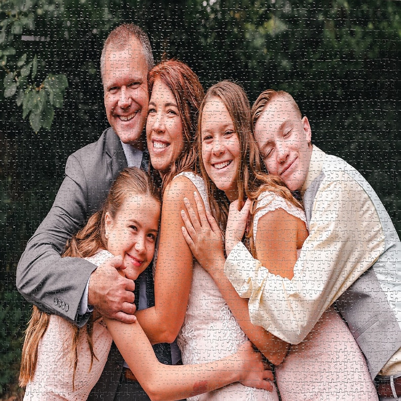 May include: A family portrait with a father, mother, two daughters, and a son. The father is wearing a gray suit jacket and the mother is wearing a white dress. The daughters are wearing pink dresses and the son is wearing a white shirt and gray vest.