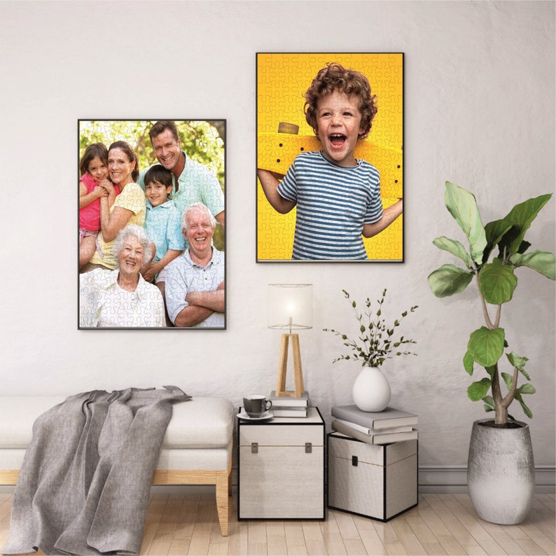 May include: Two framed photos on a white wall. The photo on the left shows a family of seven people, including grandparents, parents, and children. The photo on the right shows a young boy smiling and holding a yellow skateboard.