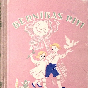 May include: A pink book cover with the title "BÉRNIBÁS RÍTI" in green letters. The cover features a smiling sun with rays of light, two children holding hands, a white dove, and a cat with a small person on its back.