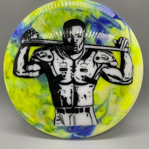 May include: A white disc with a yellow, blue, and white swirl pattern. A black and white illustration of a person wearing a football uniform and holding a baseball bat is printed on the disc.
