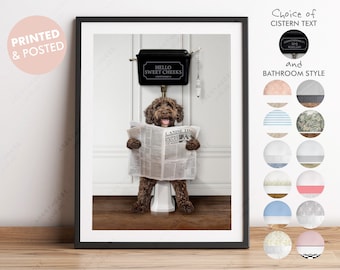 May include: A brown dog sitting on a white toilet with a newspaper in its paws. The toilet tank has a black lid with the words "Hello Sweet Cheeks" written on it.