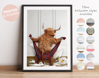 May include: A brown Highland cow with long horns is sitting in a bathtub with a red and black plaid towel. The cow is looking at the camera. The bathroom is white with a white tiled floor. There is a rubber ducky in the bathtub.