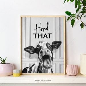 May include: Black and white photo of a cow with its mouth open, looking surprised. The text "Heard THAT" is above the cow. The photo is framed in a light wood frame.