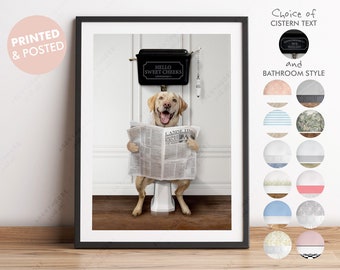 May include: A yellow Labrador Retriever dog sits on a white toilet with a newspaper in its paws. The toilet tank has a black lid with the words "Hello Sweet Cheeks" written on it.