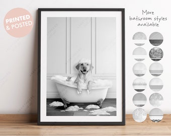 May include: Black and white framed print featuring a happy dog in a clawfoot bathtub filled with bubbles. A rubber ducky floats nearby. The print includes the text "PRINTED & POSTED" and "More bathroom styles available."