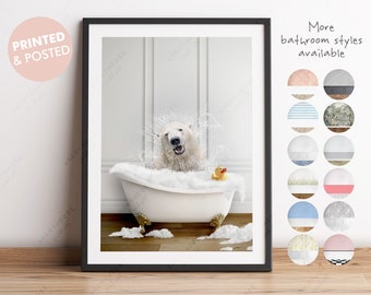 May include: A white polar bear is taking a bath in a white bathtub with bubbles. The bear is smiling and has a yellow rubber ducky in the tub with it. The bathroom has white walls and a wood floor.