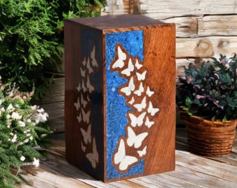 May include: A wooden storage box with a blue and white resin inlay featuring a pattern of white butterflies. The box is made of dark wood and has a natural wood finish.