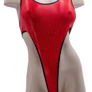 May include: A red, high-cut swimsuit with black trim. The one-piece garment has a scoop neckline and a textured, shiny appearance. The swimsuit is displayed on a mannequin.