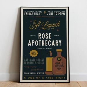May include: A framed poster with a dark teal background, featuring gold and white text. The poster advertises a "Soft Launch" at the "Rose Apothecary." It includes a candle and bottle illustration, and the text "Have a Blessed Day."