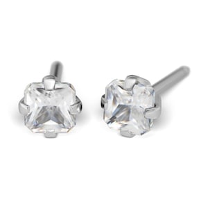 May include: A pair of silver earrings with square-shaped clear gemstones.