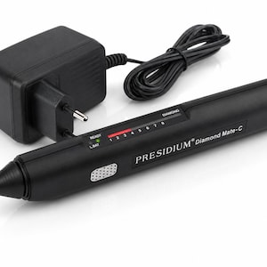 Könnte beinhalten: Schwarzer Presidium Diamond Mate-C Diamanttester mit schwarzem Netzteil und Kabel. Der Tester hat eine Spitze und ein digitales Display mit roter und grüner Anzeige. Der Text "PRESIDIUM Diamond Mate-C" ist auf der Seite aufgedruckt.