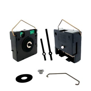 Könnte beinhalten: Uhrwerk-Set mit schwarzen Uhrzeigern, einem schwarzen Kunststoff-Uhrwerk, einem Metallbügel, einer schwarzen Unterlegscheibe und einer silbernen Mutter.