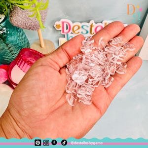 May include: A pile of clear acrylic heart-shaped charms. The charms are small and translucent, and they are perfect for adding a touch of sparkle to any craft project.
