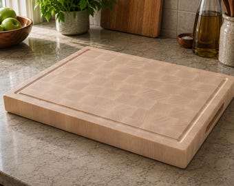 May include: A light-colored, rectangular butcher block cutting board with a juice groove and handle cutouts. The board has a checkerboard pattern and is made of wood. The board is on a countertop.
