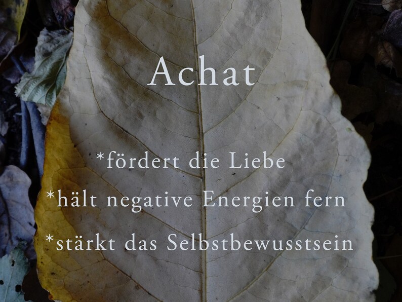 May include: A close-up of a dried leaf with the word "Achat" written on it. The leaf is a light brown colour with a yellow tint. The text on the leaf reads: *"f&ouml;rdert die Liebe" *"h&auml;lt negative Energien fern" *"st&auml;rkt das Selbstbewusstsein"