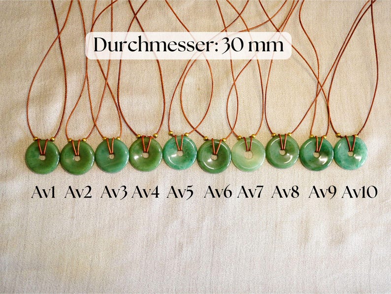 May include: Ten green jade donut pendants on brown cords. Each pendant is approximately 30 mm in diameter. The pendants are labeled Av1 through Av10. The text "Durchmesser: 30 mm" is displayed above the pendants.