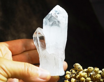 May include: A clear quartz crystal cluster with multiple points, showcasing its natural beauty and intricate formations.