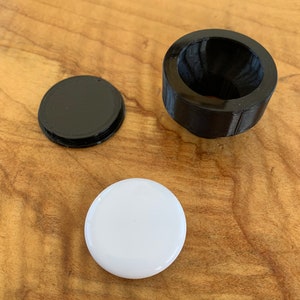 Cap and mount shown in comparison to the AirTag.