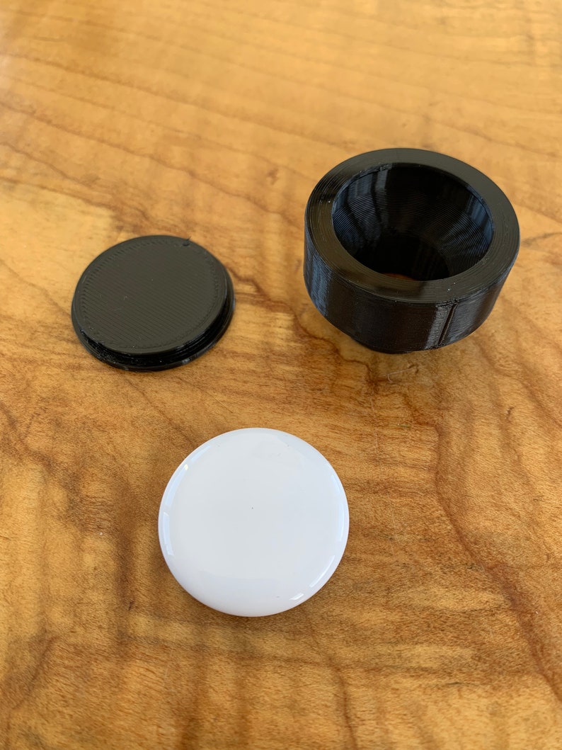 Cap and mount shown in comparison to the AirTag.