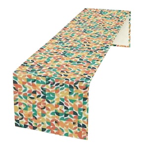 May include: A patterned table runner featuring a design of semi-circles in orange, teal, yellow, and black. The rectangular runner is made of fabric and would suit a dining table.