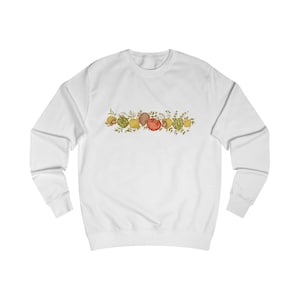 Può includere: Felpa bianca con una ghirlanda illustrata colorata di vari frutti e verdure. Il design include limoni, pomodori e altri prodotti, con fogliame verde. La felpa girocollo è realizzata in un materiale morbido.