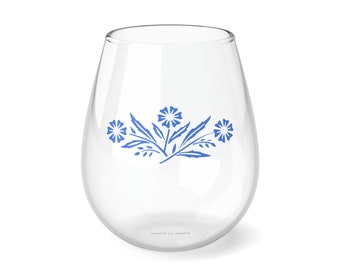 Op de afbeelding: Een helder glazen wijnglas met een blauw bloemenmotief. Het glas heeft de tekst "Made in China" op de bodem.