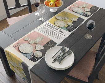 May include: A vintage-style table runner featuring a floral pattern and the text "Set Your Table In Style with Franciscan Ware...America's Own Fine-Fast China". The runner is laid out on a dark wood table with a plate and silverware.
