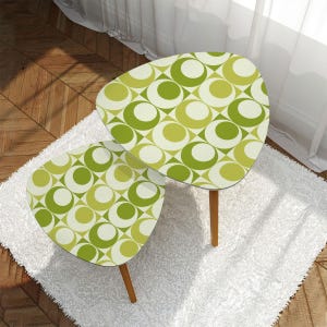 Op de afbeelding: Twee nesttafels met een geometrisch patroon in groen en wit. De tafels zijn rond en hebben een mid-century modern stijl.