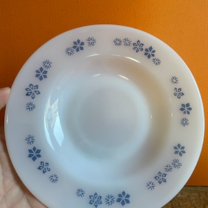 Könnte beinhalten: Ein weißer Keramikteller mit einem blauen Schneeflockenmuster am Rand.