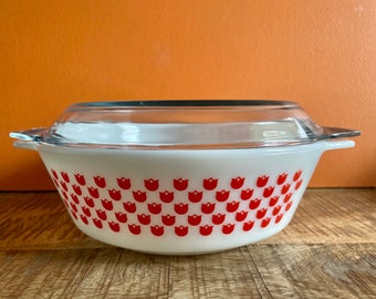 May include: White casserole dish with a red tulip pattern and a clear glass lid.