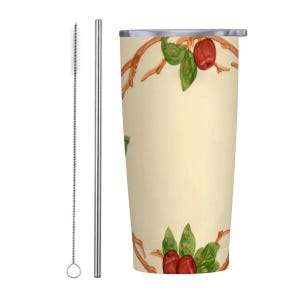 Puede incluir: Un vaso de acero inoxidable con fondo crema y un diseño de manzanas rojas y verdes. El vaso viene con una pajita de acero inoxidable y un cepillo de limpieza.