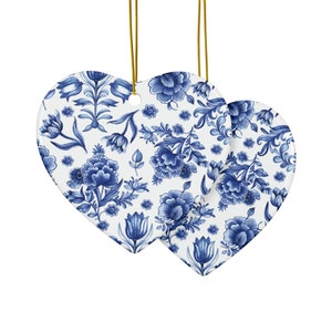 Può includere: Due ornamenti in ceramica a forma di cuore blu e bianco con un motivo floreale.