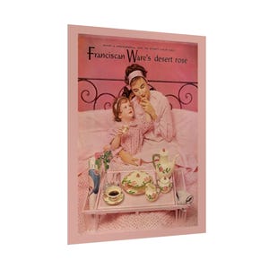 May include: Vintage advertisement for Franciscan Ware's Desert Rose dinnerware. The image features a woman and child enjoying breakfast in bed. A tray holds a teapot, teacup, saucer, and plates, all with a floral design. The text reads, "What a wonderful way to start your day!"