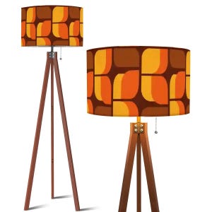 May include: Two retro-style floor lamps. The lamps feature a brown wooden tripod base and a cylindrical lampshade. The lampshades have a repeating pattern of orange, yellow, and brown abstract shapes. The lamps are designed for indoor use.