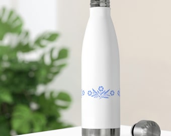 Op de afbeelding: Witte waterfles van roestvrij staal met een blauw bloemenontwerp rond het midden. De fles heeft een zilveren deksel.