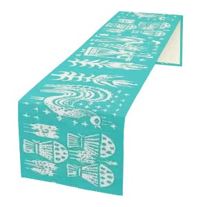 Peut inclure: Chemin de table turquoise avec un motif blanc répété de créatures marines stylisées et d'éléments nautiques. Le chemin de table est plié, révélant un dessous de couleur crème.