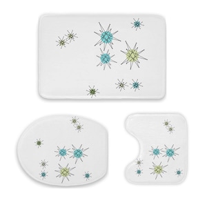 May include: A three-piece bathroom set featuring a white background with a mid-century modern starburst pattern in teal, yellow, and black. The set includes a rectangular bath mat, a rounded toilet mat, and a contoured toilet seat cover.