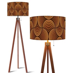 Puede incluir: Dos lámparas de pie trípode de madera. Las pantallas tienen un patrón repetitivo de líneas curvas marrones y beige. Las patas de madera son de color marrón oscuro y las lámparas tienen una cadena.