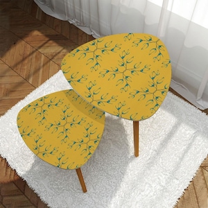 May include: A set of two nesting tables with a yellow floral pattern. The tables are made of wood and have a triangular shape. The floral pattern is in shades of blue and yellow.