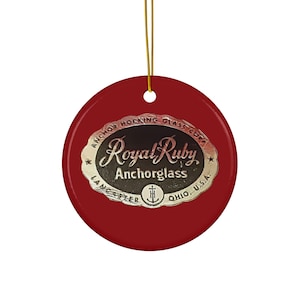 May include: Red round ceramic ornament with a white oval label that reads "Anchor Hocking Glass Corp. Royal Ruby Anchorglass Lancaster, Ohio, U.S.A."