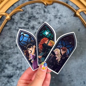 May include: Three stickers featuring romantic illustrations of couples in a stained-glass window design. Each sticker depicts a couple embracing, set against a backdrop of a night sky with a full moon. The stickers have a white border.