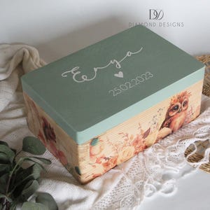 Peut inclure: Une boîte rectangulaire en bois avec un couvercle vert sauge et des côtés à imprimé floral. Le couvercle porte le nom "Enya", un cœur et la date 25.02.2023 en écriture blanche. Une illustration de hibou est sur le côté.