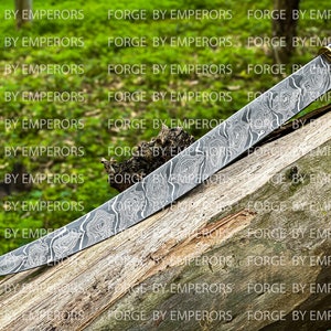 May include: A curved, silver-colored knife with a patterned blade and a wooden handle. The knife is resting on a piece of wood with a green background.