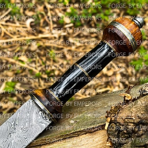 May include: A close-up of a Damascus steel knife with a wooden handle. The handle is wrapped in black leather and has a brass accent. The blade is highly polished and has a distinctive pattern.