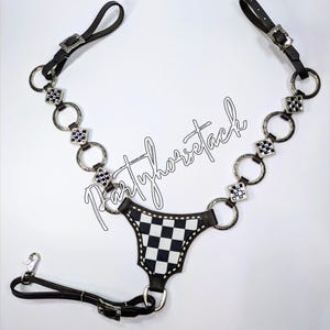 May include: Black and white checkered horse tack with silver-toned accents. The tack features a series of silver rings and square embellishments, connected by black leather straps. The text "partyhorsetack" is written in cursive.